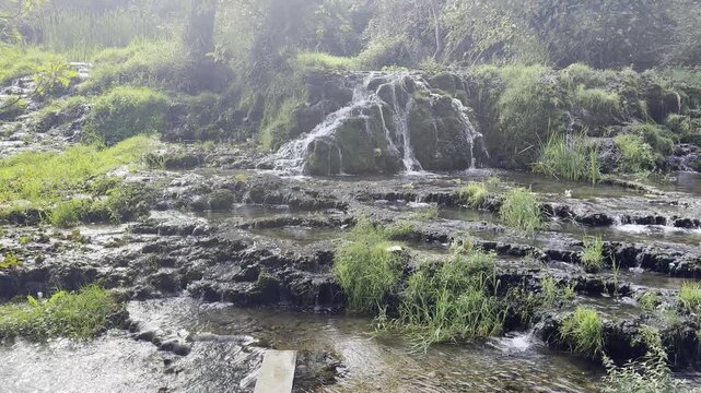 Handheld pan up shot of gentle tufa cascades and river streams above Mala Kravica Bosnia