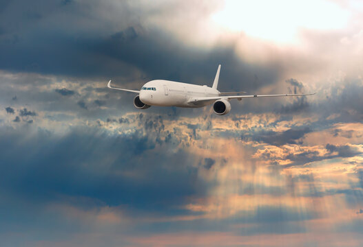 Airplane flying over tropical sea at sunset