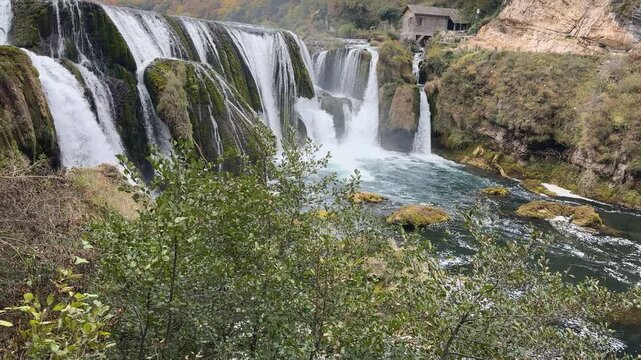 Cinematic landscape pan up shot revealing majestic Strbacki buk waterfall on the Una river