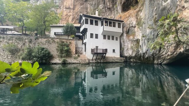 Handheld horizontal pan right from Blagaj Tekke monastery to Vrelo Bune river cave entrance