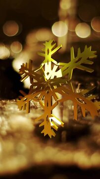 Animation of golden snowflake rotating over liquid falling on ground