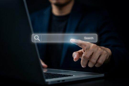 Businessman using a laptop to interact with a digital shield icon for information security.