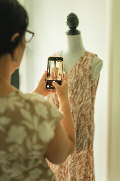 Woman photographing clothing for online resale from home