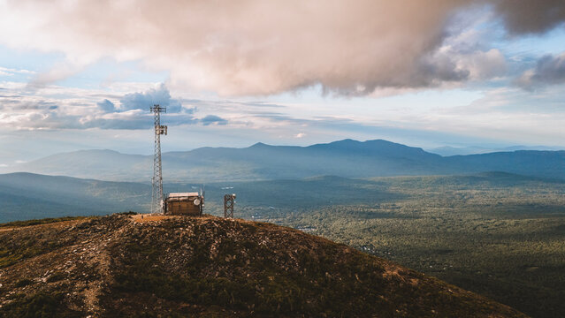 Communication tower on a mountain summit overlooking a vast valley