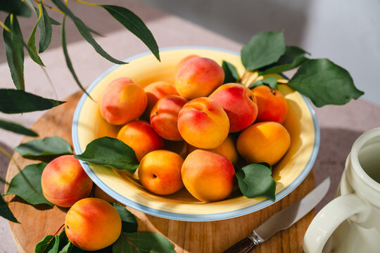 Summer fruits. Sunny still life of ripe apricots in a yellow bowl
