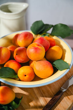 A bowl of fresh ripe apricots,  sunlight, summer food background
