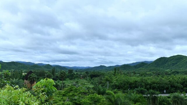 Dramatic cloud timelapse with dense white fog and mist rolling over a lush green mountain forest. Time-lapse footage.