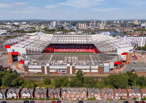 Old Trafford football stadium and Salford Quays in Greater Manchester, England, seen from above with the surrounding urban landscape.