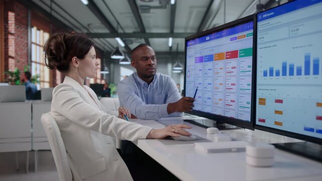 Sales Manager And Assistant Reviewing CRM Software Data Together