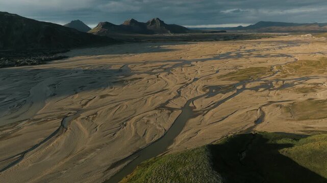 Aerial Pass Over Braided River Valley Toward Mountain Ridge