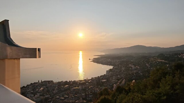 Incredible sunset viewpoint looking over the calm, sunlit, waters of Lake Geneva in Montreux, Switzerland.