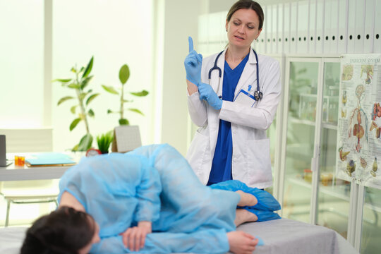 Proctologist puts on glove to examine rectum for hemorrhoids or cancer. Digital rectal examination