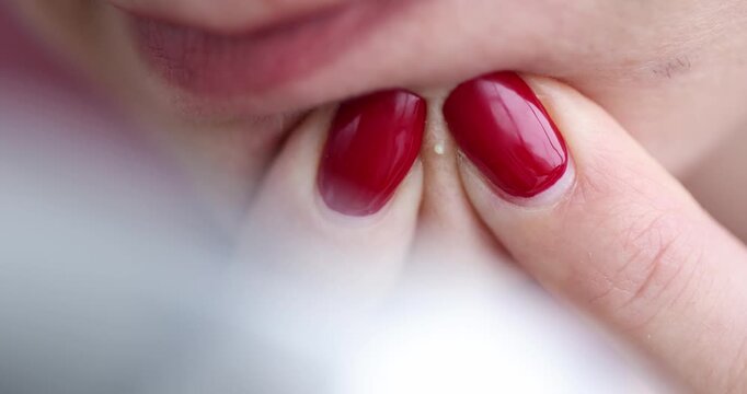 A gentle hand glides over polished red nails as warm light surrounds the scene. The tranquil atmosphere highlights the artistry in simple grooming rituals.