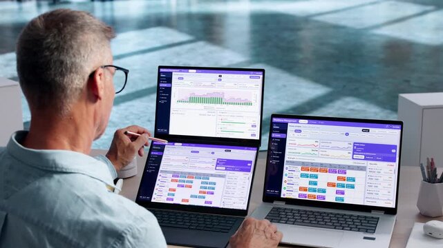 Mature Manager Points At Laptop Screen
