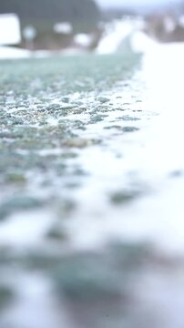 An empty winter highway during the day, shot from a low angle in a snowstorm.