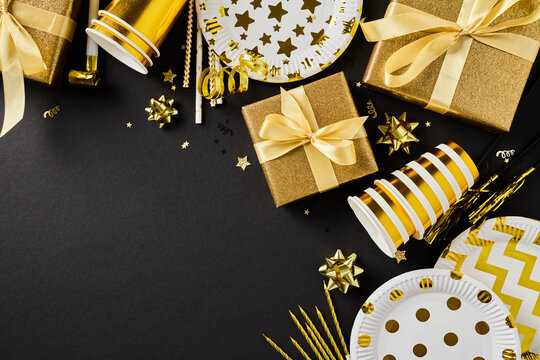 Golden party decor and present boxes corner frame black background