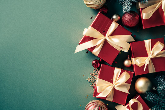 Christmas gifts and red baubles side border on green background