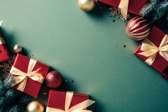 Red Christmas gifts and baubles corner frame on green background