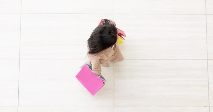 People navigate through a vibrant mall, carrying colorful bags filled with treasures. Laughter and chatter fill the air as they enjoy their day out.