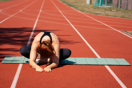 woman stretching sitting running track red surface outdoor physical activity healthy lifestyle concept of sport fitness wellness