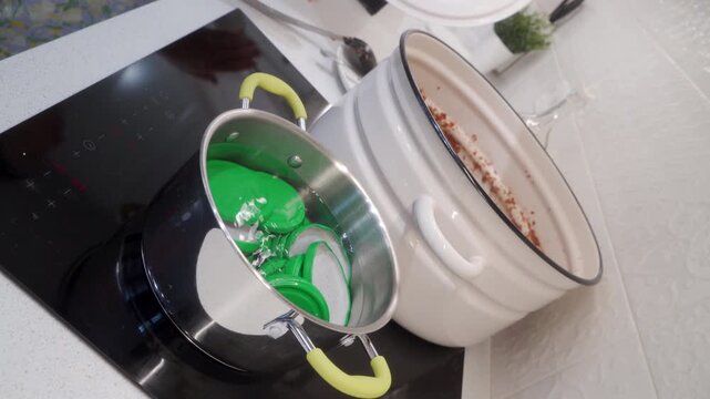 Green jar lids sterilize in boiling water beside a large pot on a cooktop. Someone carefully prepares homemade food in a cozy kitchen. The process brings a warm, satisfying feeling.