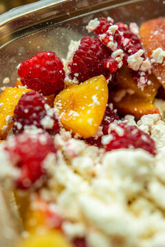 Fresh raspberries and sliced peaches with cottage cheese close up