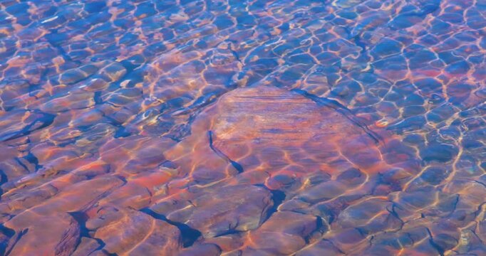 4k video; sunlight rippling over rocks on the bottom of a lake in Norway