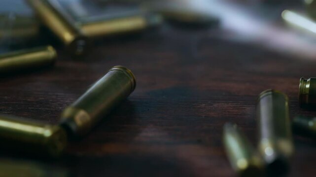 Ammunition falling through swirling smoke on a dark surface, evoking the chaos, fear and destruction of war, battle and armed conflict. Cinematic military concept.