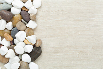 White pebble stones on wooden background, top view © Liami