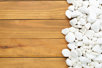 White pebble stones on wooden background, top view © Liami