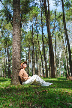 Vertical portrait image of a woman sitting and relaxing in the park