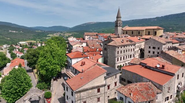 aerial drone view of Buzet historic medieval town in Istria Croatia at early summer showing old stone buildings, hilltop settlement, surrounding forests and green valley landscape