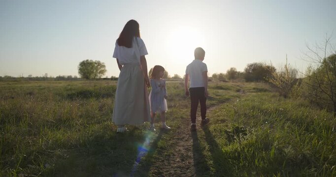 Family rest near Lake. Young mother spend time with children son and daughter enjoying nature. 4K 10-bit