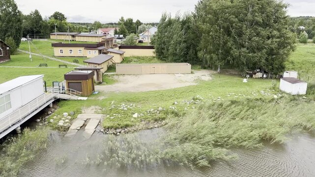 Vologda Oblast, Russia, August 14, 2026. View of the pier and the river from a historic wooden structure at the Ethnographic Complex &ldquo;Zastava of the Belozersky Princes,&rdquo; surrounded by green grass 
