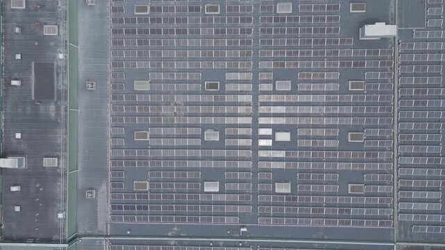 Aerial top down view of solar panels on an industrial building roof