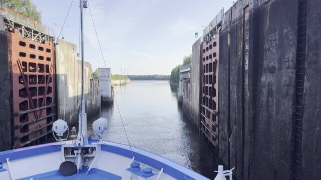Podporozhye, Leningrad Region, Russia. A cruise ship approaches the lock on the Svir River near the Verkhne-Svirskaya Hydroelectric Power Station. Viewed from the bow, the massive lock gates slowly op