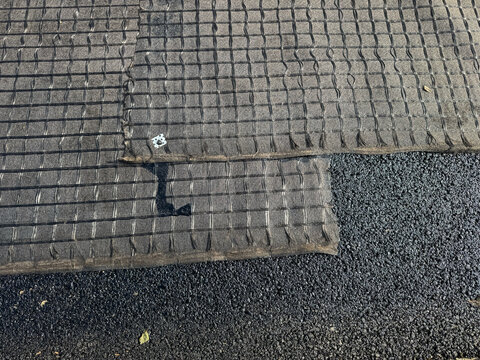 Overlapping Geogrid Fabric Reinforces a Fresh Asphalt Road Surface