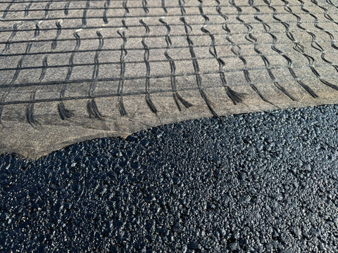 Geogrid Reinforcement Fabric Covers a Fresh Asphalt Road Layer