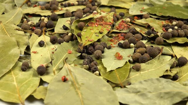 Dried bay leaves, allspice, peppercorns, flat lay, food background, side view