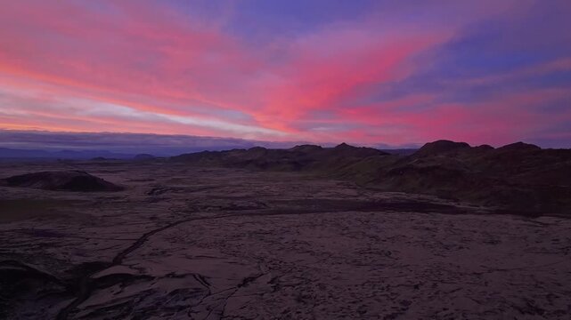 Pink solstice clouds glow above Reykjanesbaer volcanic terrain at midnight