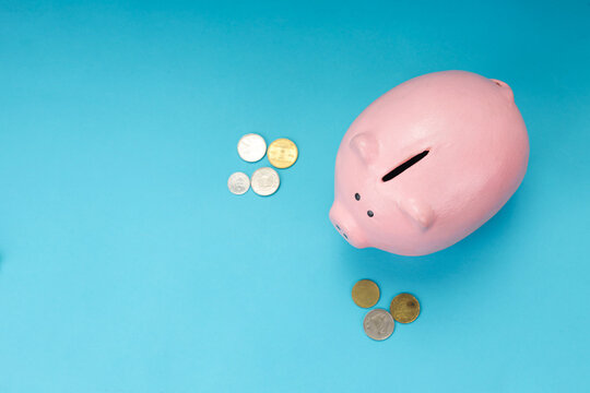 Closeup of Piggy Bank with Scattered Coins for Financial Savings