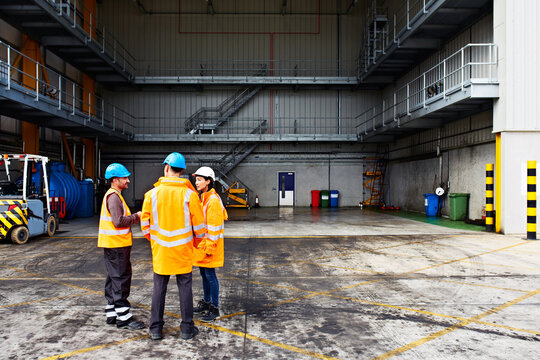 Supply chain, team or talk in loading dock for shipping coordination, dispatch priorities or agenda. Men, supervisor or logistics meeting in shipyard for shift briefing, port operations or management