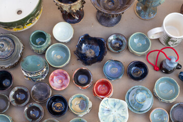 Colorful handmade ceramic cups and bowls top view photograph at outdoor craft market
