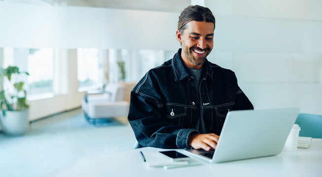 Man works on laptop in a bright office