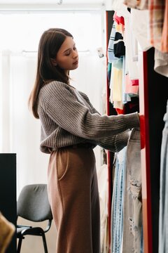 Young woman shopping for clothes in retail store