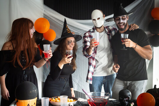 Friends laughing together at a Halloween costume party