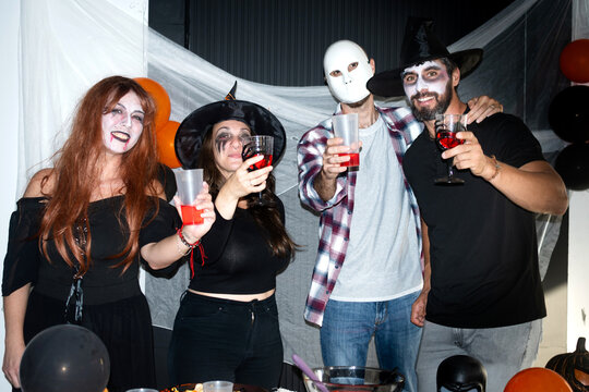Friends raising drinks at Halloween costume party