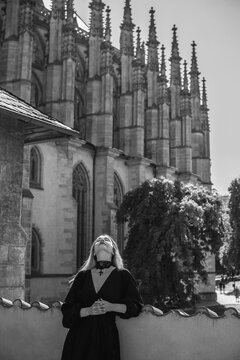 Woman exploring historic streets of Kutna Hora with St. Barbara Cathedral in background, Czech Republic travel concept