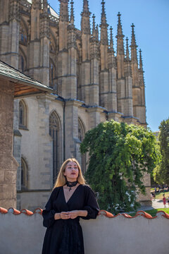 Woman exploring historic streets of Kutna Hora with St. Barbara Cathedral in background, Czech Republic travel concept