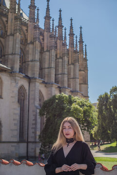 Woman exploring historic streets of Kutna Hora with St. Barbara Cathedral in background, Czech Republic travel concept